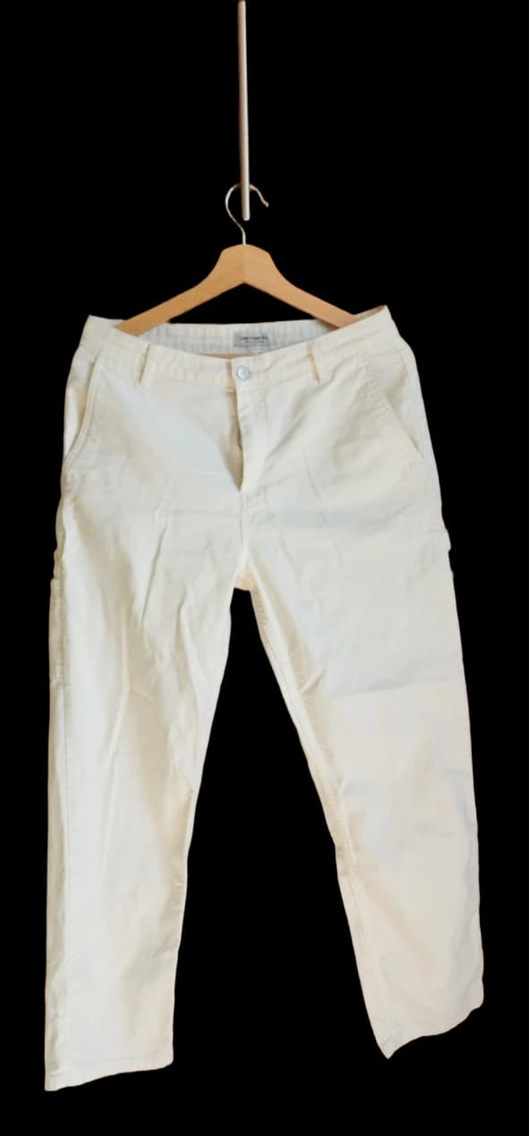 Cream straight-leg trousers on a wooden hanger