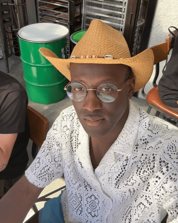Elias, Fitr co-founder, wearing glasses and a straw hat